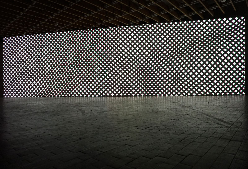 In 'Okeanus', a lattice model of the sea surface casts shadows whose gradually thickening mesh lines emerge from the white void and eventually disappear into blackness.